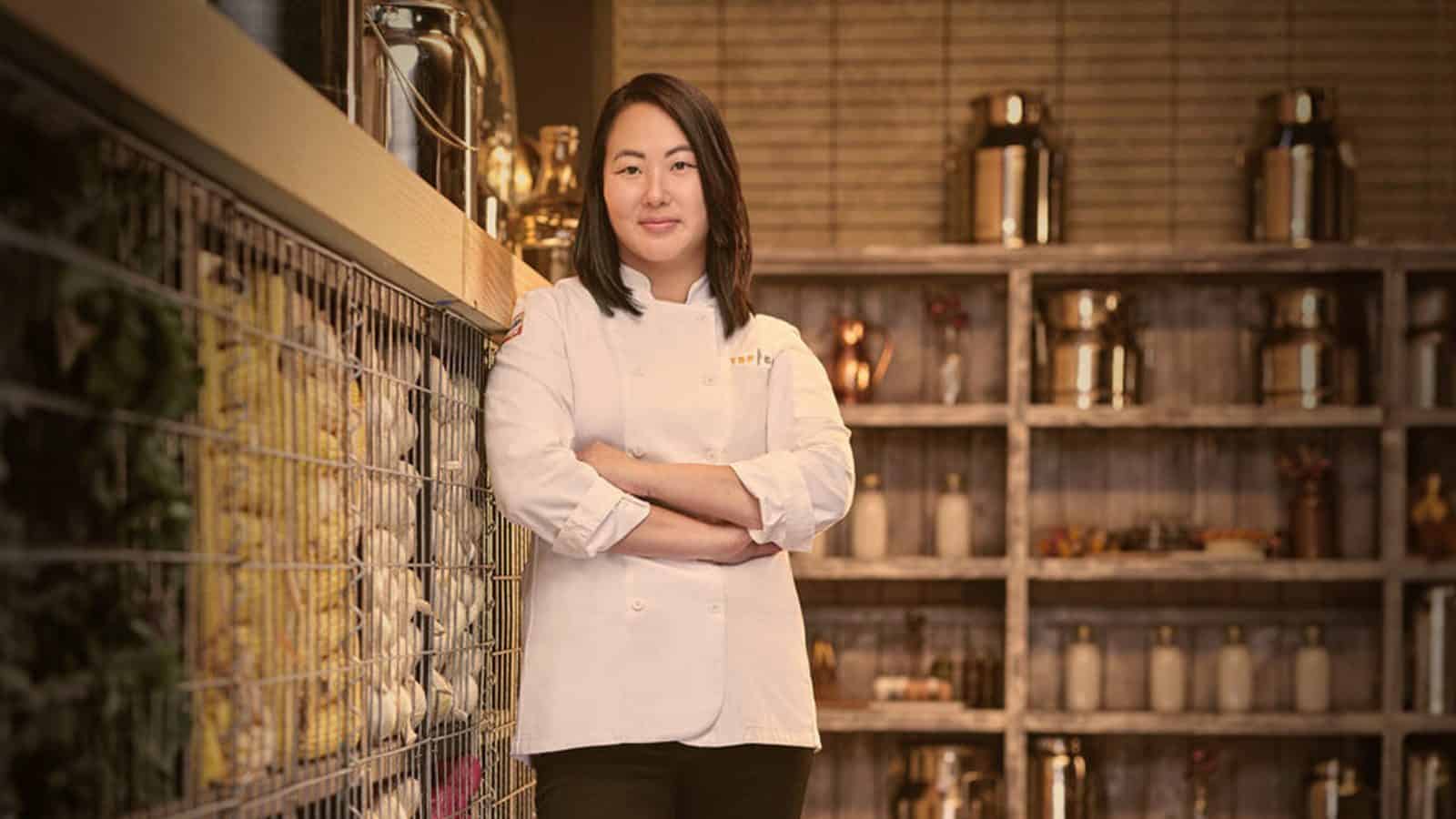 KaleenaBliss_16x9 A Top Chef Kaleena Bliss with crossed arms standing proudly in a restaurant kitchen.